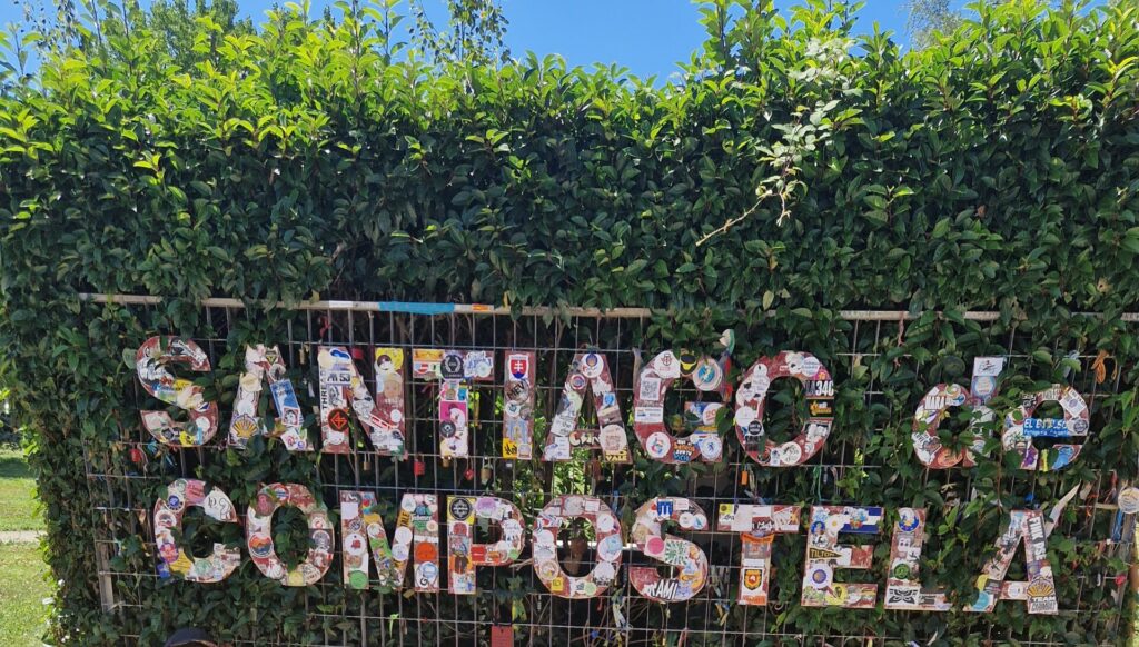 Cartel del Camino de Santiago en un arbusto, entrando a la ciudad de Santiago de Compostela .Un puente de piedra en el Camino de Santiago. Etapas del Camino de Santiago con perro